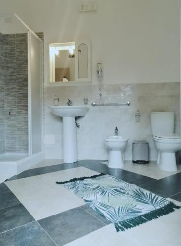 a bathroom with a sink and two toilets at b & b Jasmine in Santa Teresa di Riva