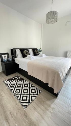 a white bedroom with a large bed and a rug at Albina's luxury Villa 3 bedroom in Hanioti