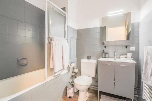 a white bathroom with a toilet and a sink at Le Jaude Centre studio in Clermont-Ferrand