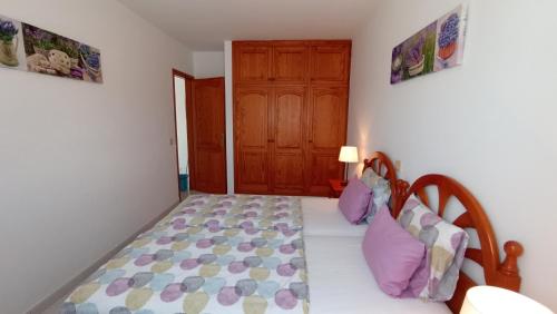 a bedroom with a bed and a wooden door at Apartments Casa Blanca in Charco del Palo