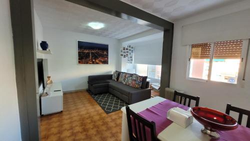 sala de estar con mesa y sofá en APARTAMENTS B O D CoLLBLANC, en Hospitalet de Llobregat