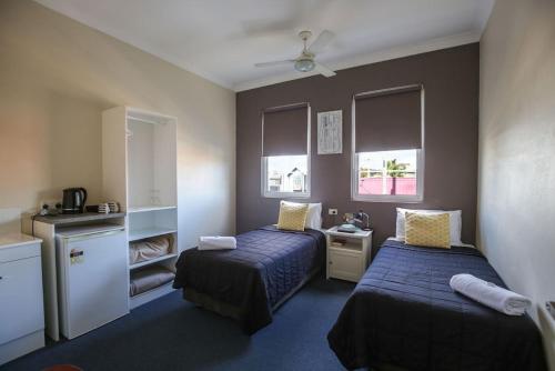 um quarto com duas camas e duas janelas em Bayview Hotel Woy Woy em Woy Woy