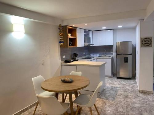a kitchen with a table and chairs and a refrigerator at Hermoso apartamento recién remodelado zona top in San Andrés