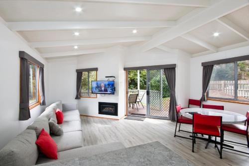 a living room with a couch and a table at Cumberland River Holiday Park in Lorne