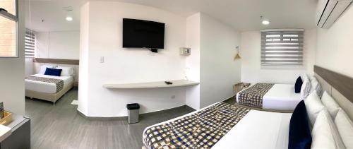 a hotel room with two beds and a tv at Seven Inn Hotel in Medellín