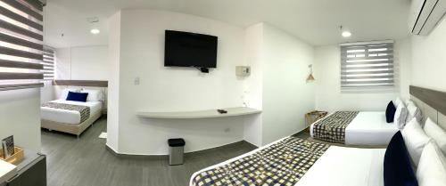 a hotel room with two beds and a flat screen tv at Seven Inn Hotel in Medellín