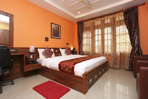 a bedroom with a bed and a desk and a window at Super Hotel O Cherry City Cottage in Guwahati