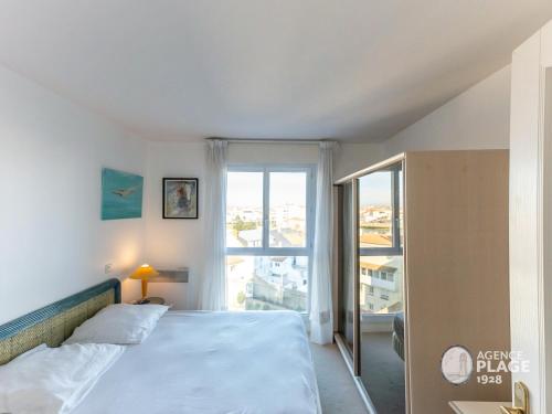 ein Schlafzimmer mit einem Bett und einem großen Fenster in der Unterkunft Appartement T2 face plage avec garage aux Sables-d'Olonne - FR-1-197-213 in Les Sables-dʼOlonne