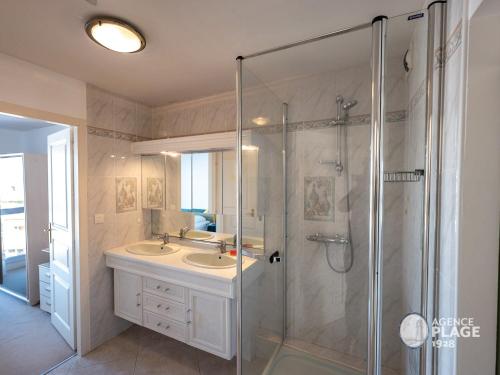 ein Badezimmer mit zwei Waschbecken und einer Dusche mit Glastür in der Unterkunft Appartement T2 face plage avec garage aux Sables-d'Olonne - FR-1-197-213 in Les Sables-dʼOlonne