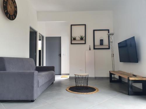a living room with a couch and a table at L'écrin des calumets in La Plaine des Palmistes