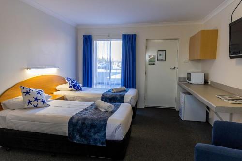 a hotel room with two beds and a kitchen at The Busselton Motel in Busselton