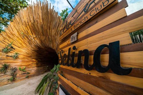 a sign on a wooden fence with a sign on it at Selina Tulum in Tulum