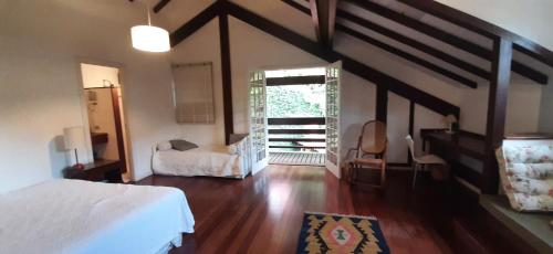 a bedroom with a bed and a room with a window at Casa Itaipava Country Club in Petrópolis