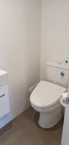 a white bathroom with a toilet and a sink at Lakefront Apartments,18 LAKE ESPLANADE ROAD in Queenstown
