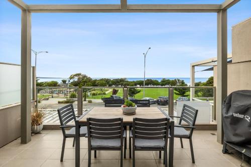 a dining room with a table and chairs on a patio at Waterfront One Ocean Bliss in Lorne