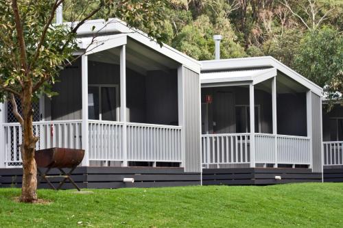 a white screened in porch on a house at Cumberland River Holiday Park in Lorne