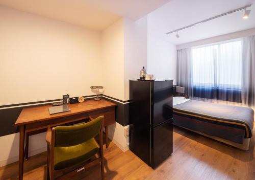 a room with a desk and a bed and a desk sidx sidx sidx at Hotel Graphy Nezu in Tokyo