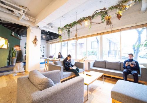 a group of people sitting on couches in a room at Hotel Graphy Nezu in Tokyo
