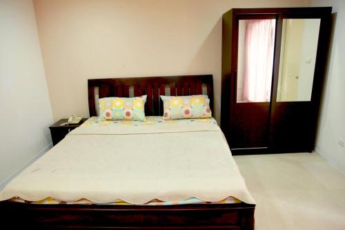 a bedroom with a large bed and a door at Mee sook Hotel and Residence in Nonthaburi