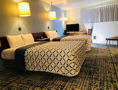 a hotel room with two beds and a television at Curly Redwood Lodge in Crescent City