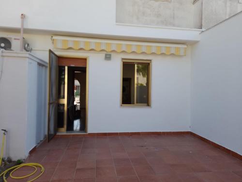 una puerta abierta de un edificio blanco con patio en Casa Ercole, en Torre dell'Orso