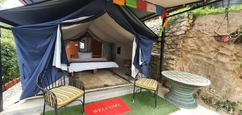 a tent with a bed and two chairs and a table at Shivapuri Heights Cottage in Kathmandu