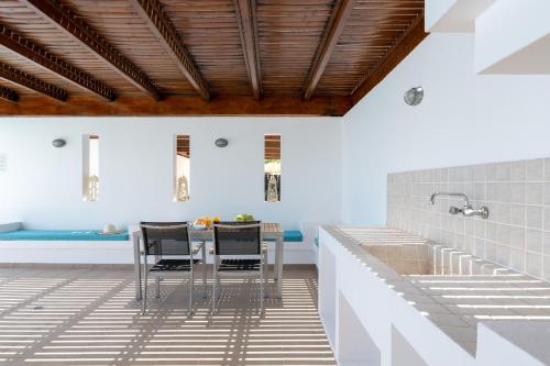eine Küche mit einem Tisch und Stühlen auf einem Fliesenboden in der Unterkunft Villa Milena with private pool, Vlicha beach Lindos in Lindos