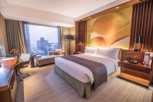 a hotel room with a large bed and a window at Marco Polo Ortigas Manila in Manila