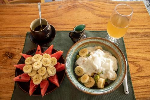 a table with a bowl of fruit and a glass of orange juice at HOI AN HEART LODGE in Hoi An