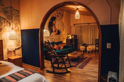 a bedroom with an archway and a living room with a couch at Selina Huaraz in Huaraz