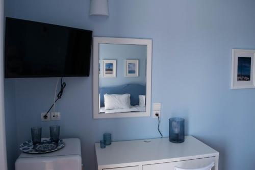 ein Wohnzimmer mit einem TV und einem Spiegel in der Unterkunft Mirtia Hotel in Pefki