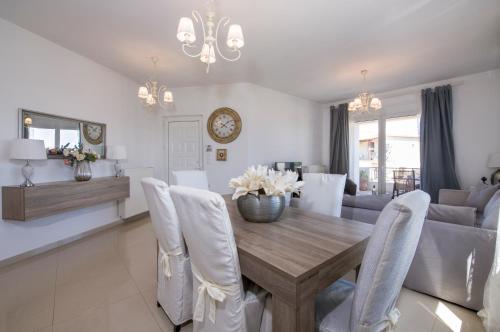 a dining room and living room with a table and chairs at Casa Magnolia in Kathiana