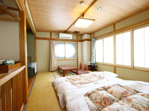 a bedroom with a bed and a window at Hotel Yudanaka in Yamanouchi