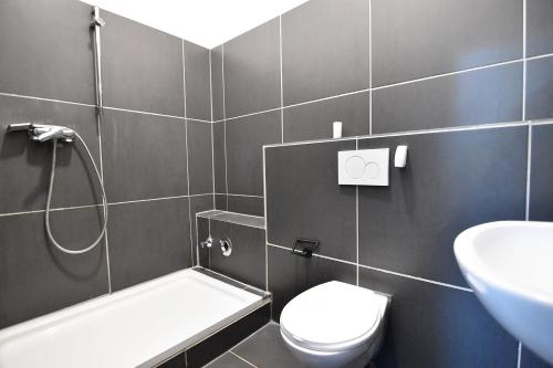 y baño con ducha, aseo y lavamanos. en one room apartment in Köln, en Colonia