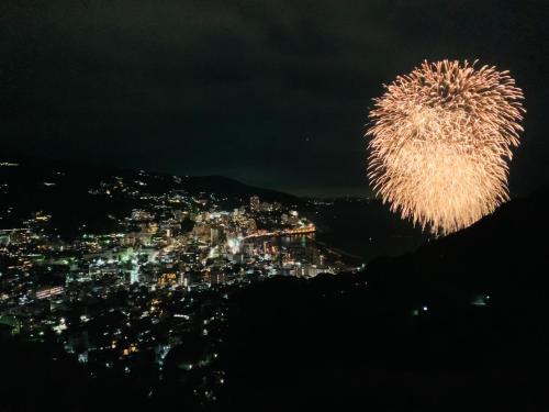 a fireworks display over a city at night at 熱海天海ヴィラ/ Atami Tenkai Villa in Atami