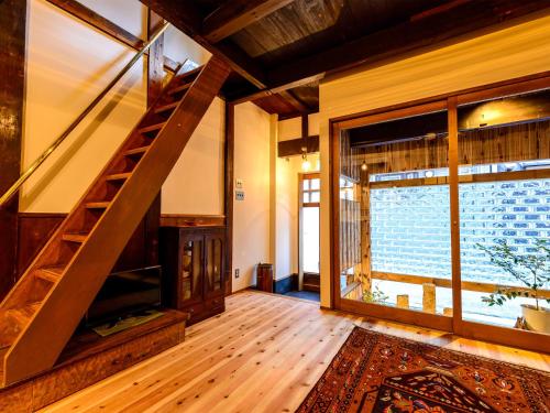 a living room with a staircase and a large window at Koume no Hanare コウメノハナレ in Kyoto