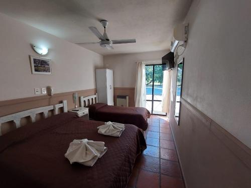 a hotel room with two beds and a window at Santa Catalina Hotel in San Antonio de Areco