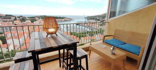 d'un balcon avec une table et un banc offrant une vue. dans l'établissement Soleil, Vue & Confort à Tara, à Port-Vendres