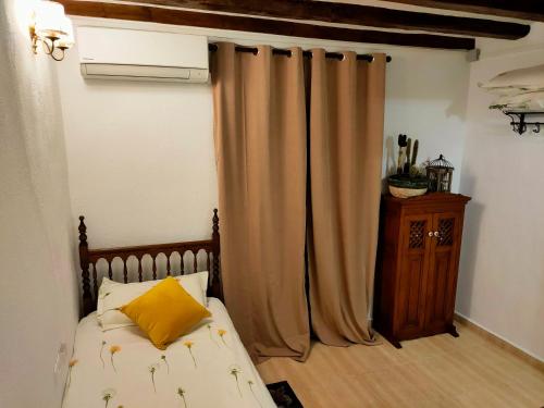 um quarto com uma cama com uma almofada amarela em 2 Tus vacaciones ideales en TARRAGONA em Tarragona