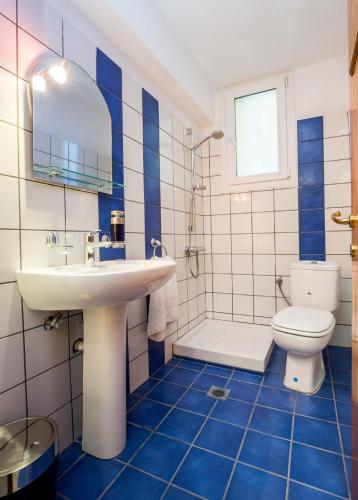 a blue and white bathroom with a sink and a toilet at BELUGA HOUSE in Skala Rachoniou