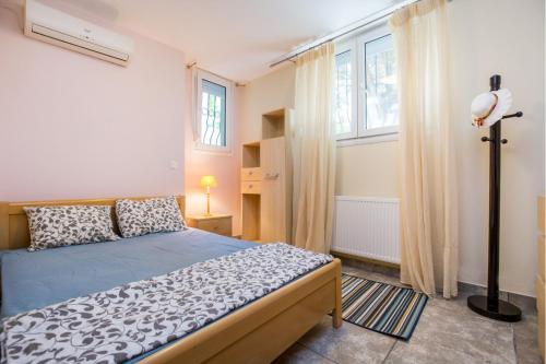 a bedroom with a bed and two windows at BELUGA HOUSE in Skala Rachoniou