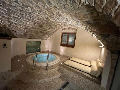 a large bathroom with a tub in a stone building at Hotel Palazzo Squarcialupi in Castellina in Chianti