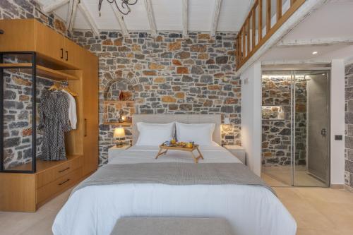 EliaにあるELECTRA BOUTIQUE VILLAのレンガの壁、大きなベッド付きのベッドルーム1室