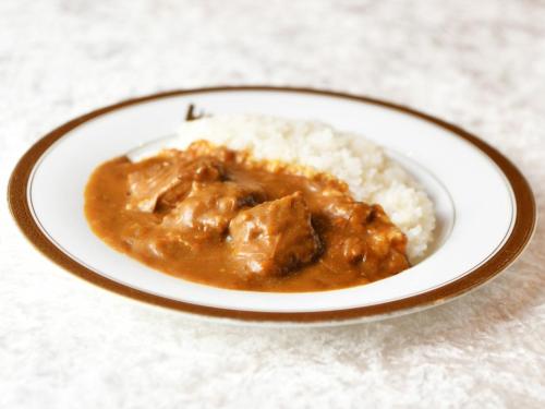 a plate of food with meat and gravy and rice at Atsugi Urban Hotel in Atsugi