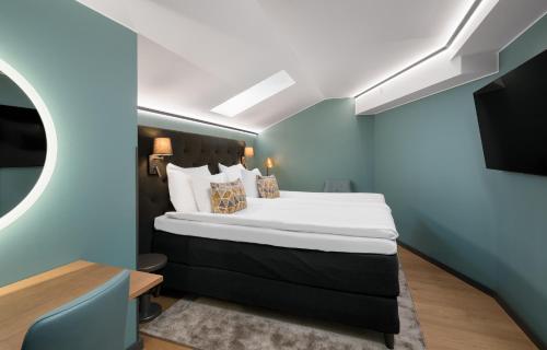 a bedroom with a large bed with a blue wall at Hotel Kakola in Turku