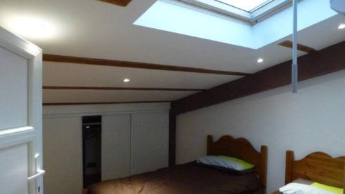 a bedroom with a bed and a skylight at L'Eterlou Saint Blaise, bel appartement neuf mansardé in Saint-Blaise