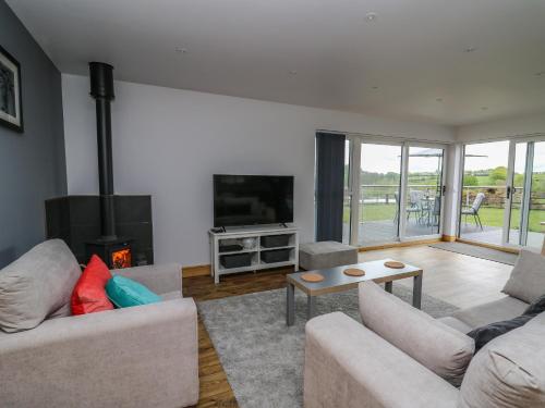 a living room with two couches and a tv at Llyn Cae Ty Nant Fishery Holiday Let in Lampeter