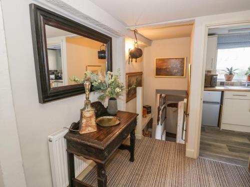 a room with a table with a mirror and a kitchen at Burrows Court in Tewkesbury