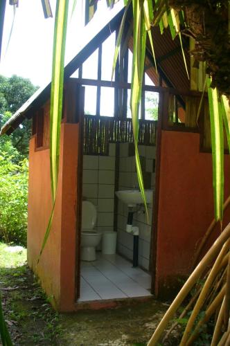 a bathroom with a toilet and a sink in a building at Los Mineros Guesthouse in Dos Brazos