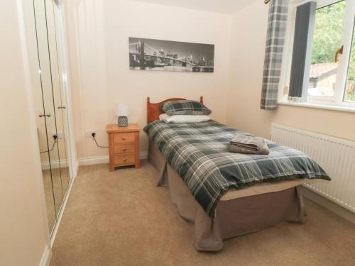 ein kleines Schlafzimmer mit einem Bett und einem Fenster in der Unterkunft Cherry Garth in Whitby